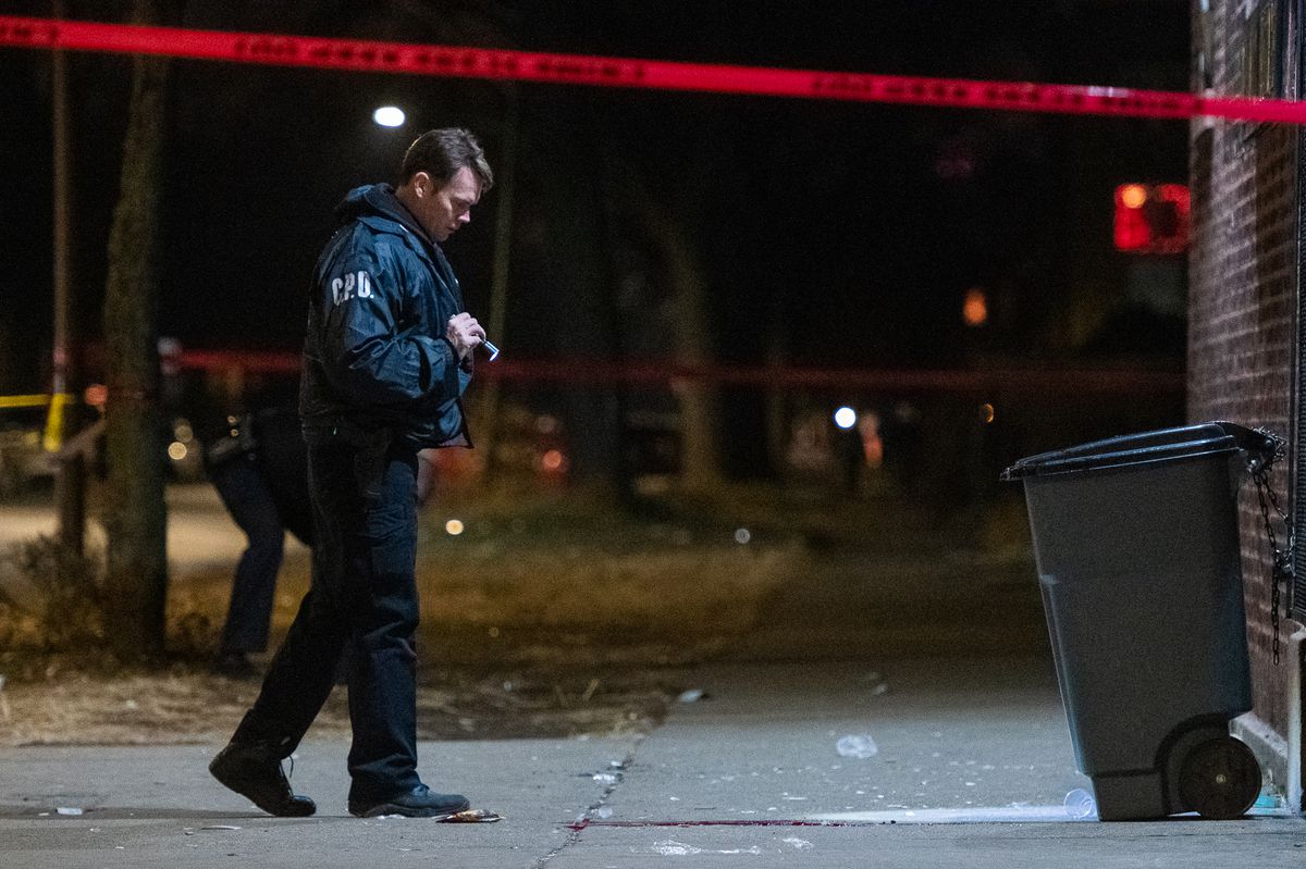 A Chicago Police Officer looks a pool of blood at the scene where a man was shot Monday night in the 7500 block of South Stewart in the Englewood neighborhood. | Tyler LaRiviere/Sun-Times
