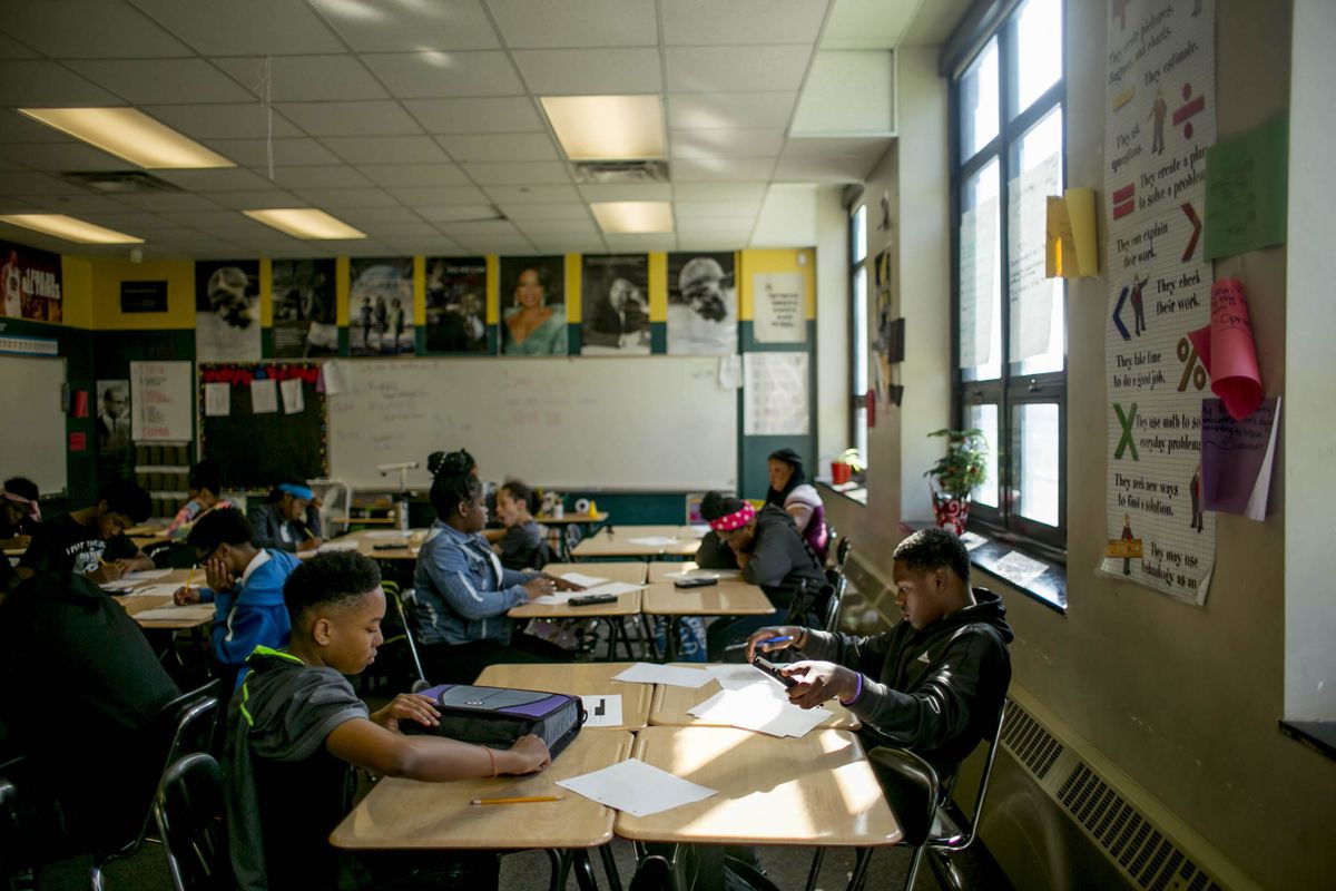 Several high school students work independently at their desks in a classroom.