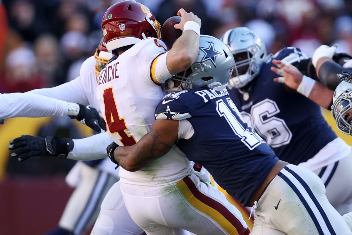 Micah Parsons #11 of the Dallas Cowboys forces Taylor Heinicke #4 of the Washington Football Team to fumble and is returned for a touchdown by Dorance Armstrong #92 (not pictured) during the first quarter at FedExField on December 12, 2021 in Landover, Maryland.