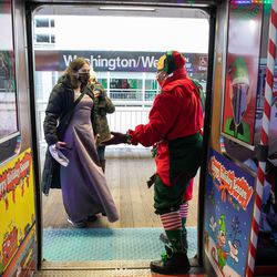 Cassie Collins “Elf Sugaaa,” who is dressed as an elf, waves to a passenger who is boarding the Allstate Chicago Transit Authority (CTA) Holiday Train, which circled the Loop, Monday afternoon, Dec. 20, 2021. | Pat Nabong/Sun-Times