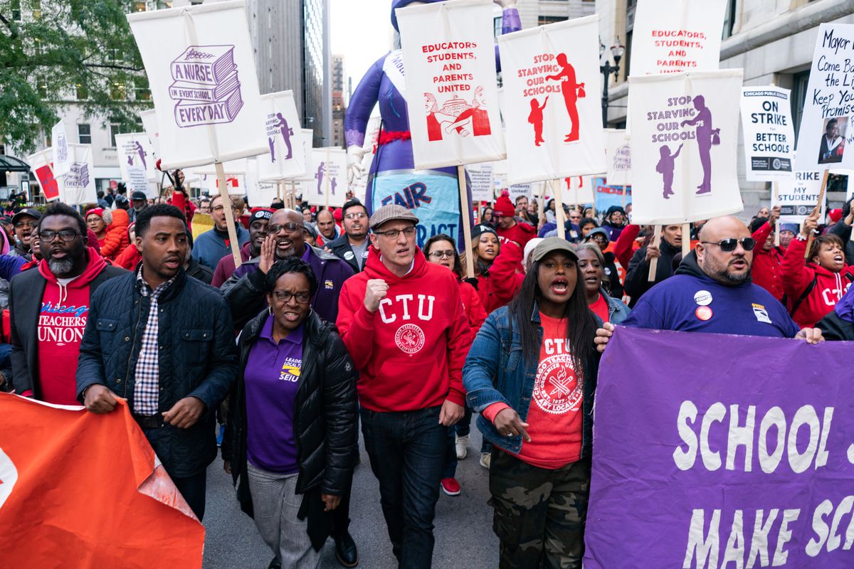 Chicago Teachers Union President Jesse Sharkey (center-left) and Vice President Stacy Davis Gates (center-right) march in downtown Chicago during the union's 11-day strike last fall.