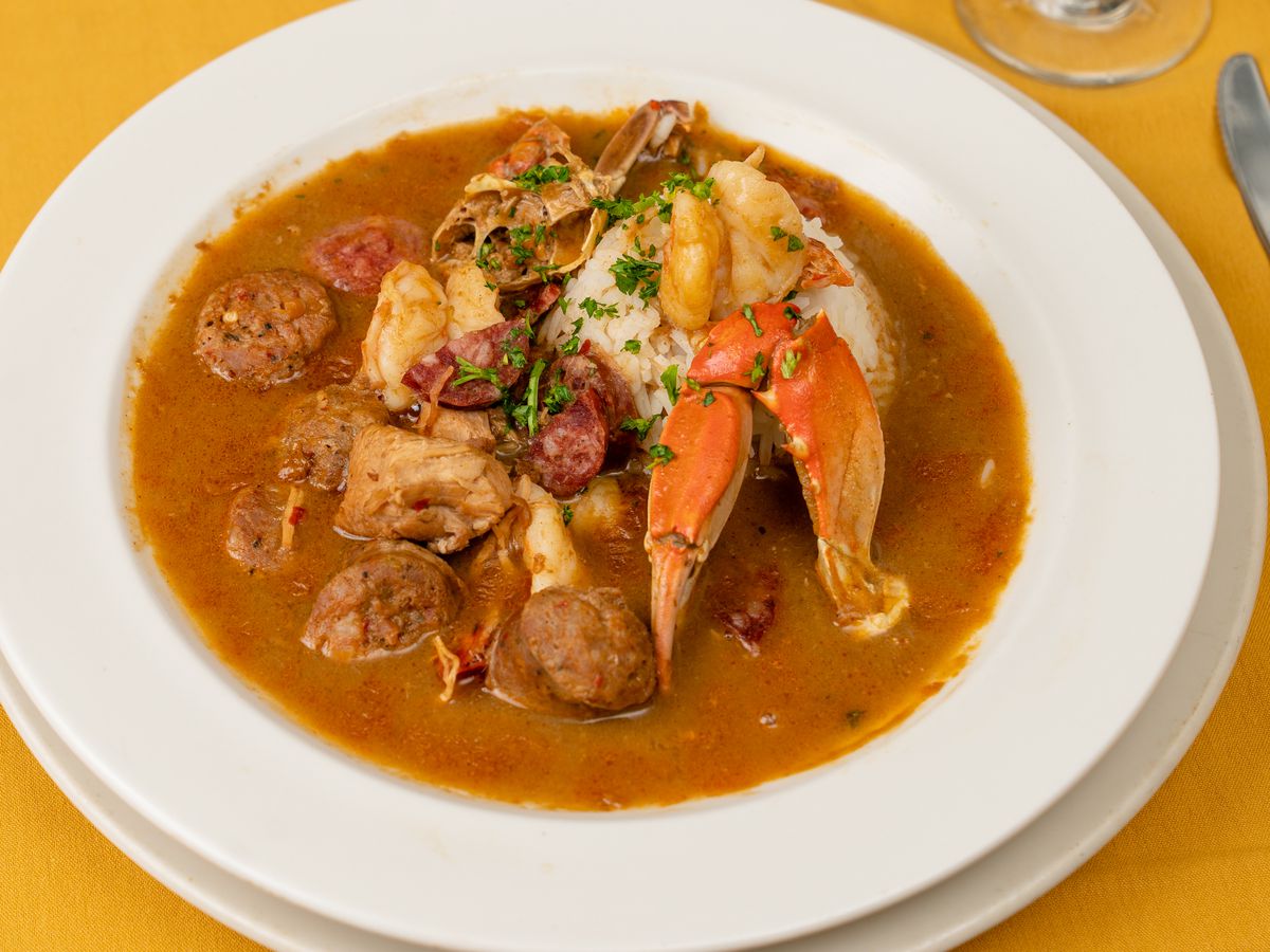 A bowl of gumbo on a yellow table