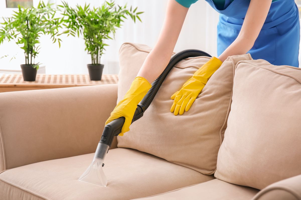 Someone with yellow gloves cleaning upholstery