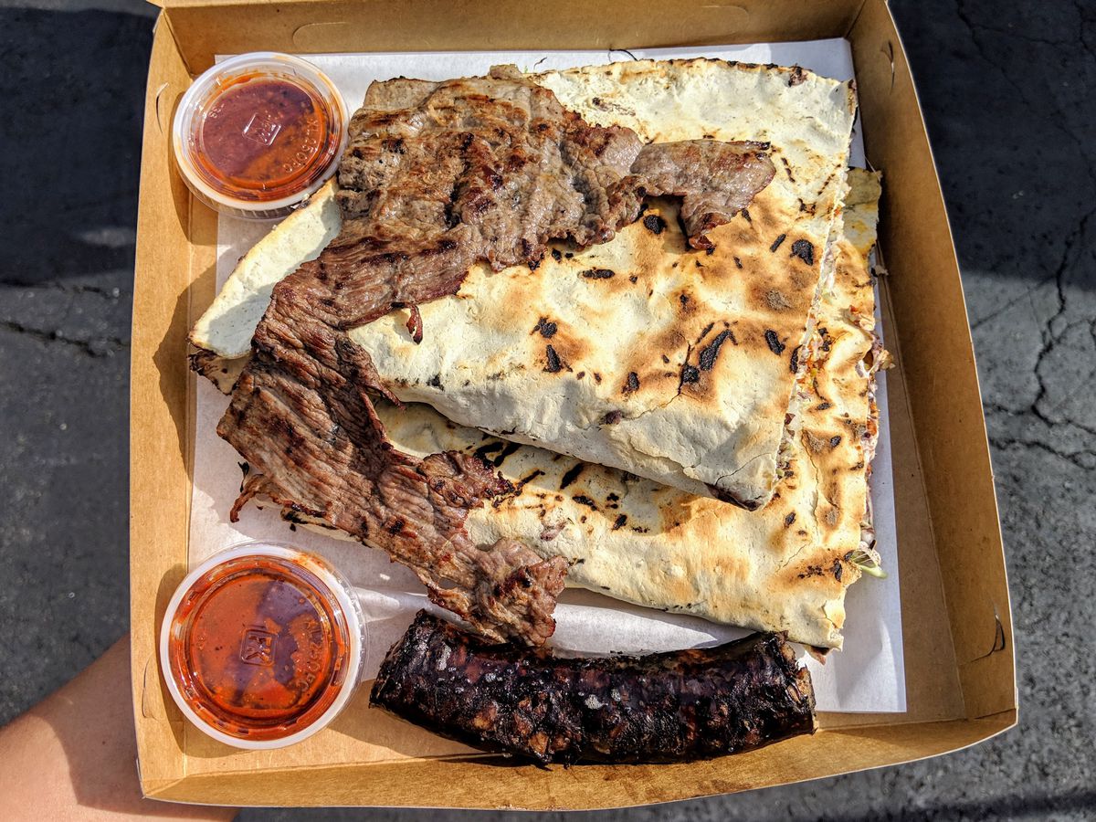 Tlayudas with tasajo and moronga from Poncho’s in a paper box.