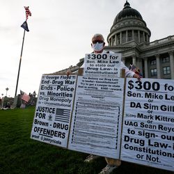 A spectator holds a handmade clipboard during the Silent Majority March at the state Capitol in Salt Lake City on Saturday, Aug. 1, 2020.