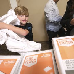 Chase Hansen, 9-year-old CEO of Kid Labs and a Leesa “social changemaker,” helps unwrap mattress covers at the Rescue Mission of Salt Lake on World Homeless Day in Salt Lake City on Wednesday, Oct. 10, 2018. Leesa Sleeps donated 150 mattresses to the mission.