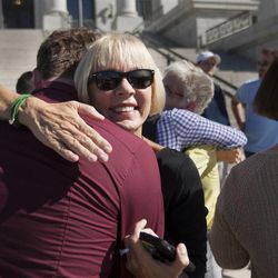 Donna Weinholtz hugs Matt Conway after a press conference held by the LGBT rights protesters known as the “Capitol 13” in response to the charges that have been filed against them, Thursday, Aug. 28, 2014.