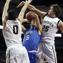Dixie guard Tyler Bennett (5) shoots against Desert Hills forward Tanner Leishman (0) and guard Austin Adams (25) as Desert Hills and Dixie play in the 3A boys basketball semifinals at the Maverik Center in West Valley City Friday, Feb. 27, 2015.
