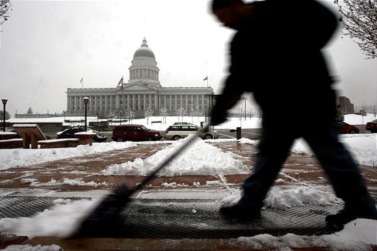 Luis Hernandez shovels the snow on Council Hall's property across from the Utah State Capitol on Thursday.