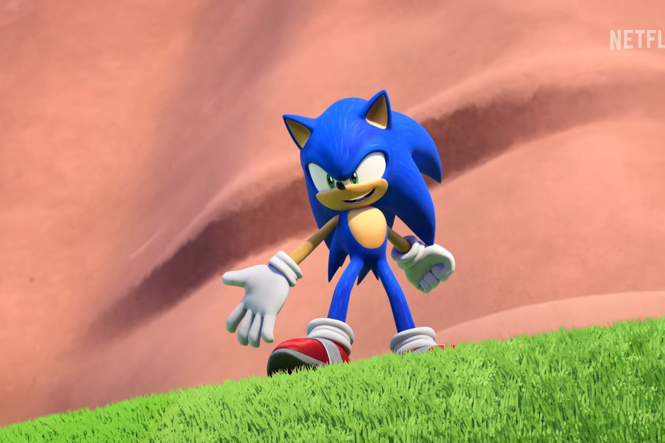 In a still from Netflix’s upcoming Sonic Prime show, Sonic stands on grass in front of a brown, rocky wall.