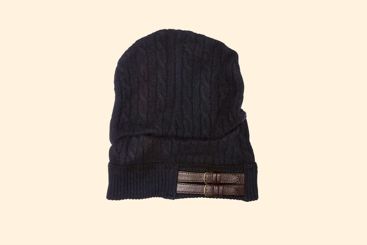 A navy Galadriel Mattei knit hat with two buckles across the side