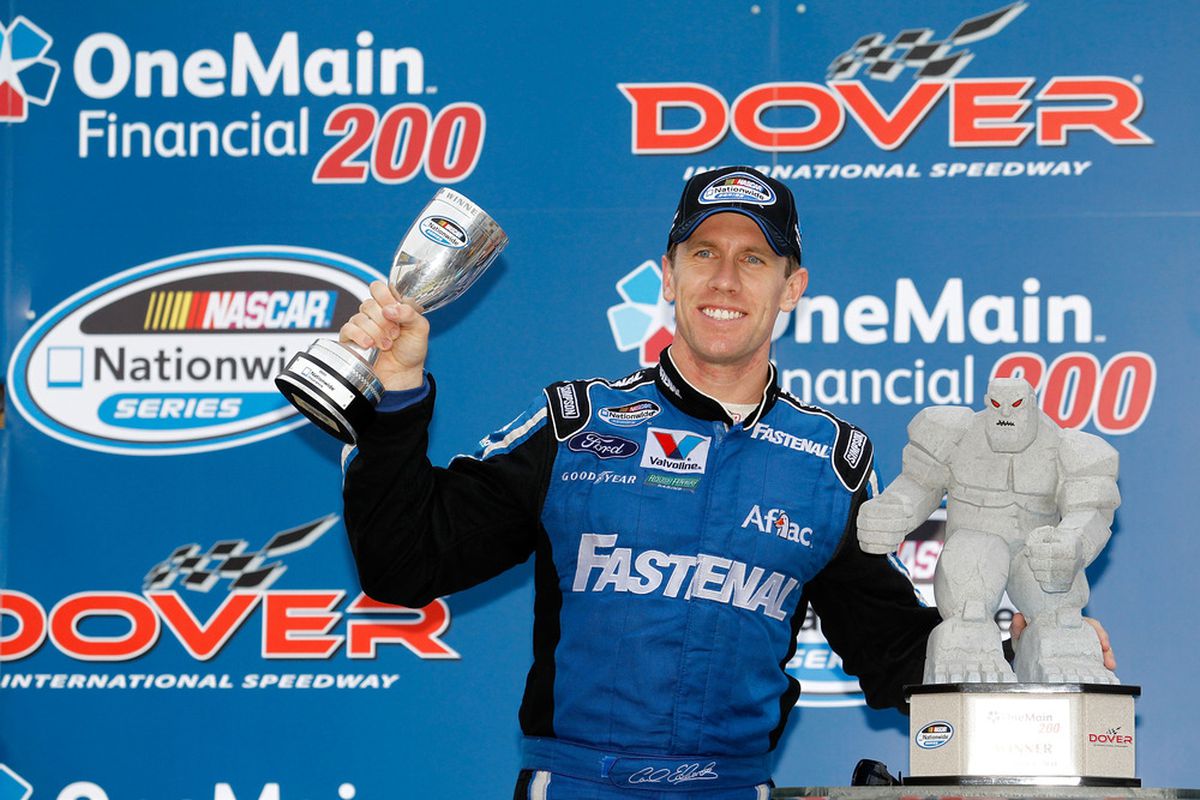 Carl Edwards celebrates with his race trophy and Nationwide trophy as he celebrates in victory lane after he won the NASCAR Nationwide Series OneMain Financial 200 at Dover International Speedway.