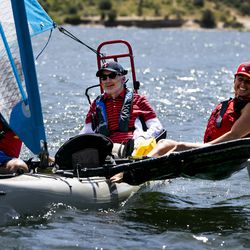 Derek Sundquist, center, controls a sailboat while nurse Jolene Grovum laughs in one of the outrigger seats while sailing on East Canyon Reservoir in East Canyon State Park on Thursday, July 18, 2019. The sailboat is equipped with technology that allows Sundquist, a quadriplegic, to control the speed and direction of the craft with blows and sucks through a straw.