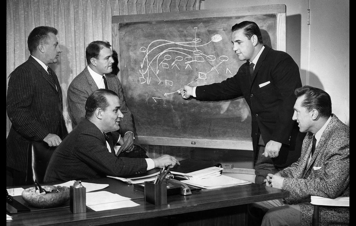 March, 1960: Los Angeles Chargers coaching staff moved into new offices at 1017 La Brea. Here assistant Jack Faulkner diagrams play for Joe Madro, left, Chuck Noll; head coach Sid Gillman (seated) and Al Davis. In 1959, Madra, Faulkner and Gillman were with the Los Angeles Rams; Noll with Cleveland Browns and Davis with USC. This photo was published in the March 15, 1960 Los Angeles Times.