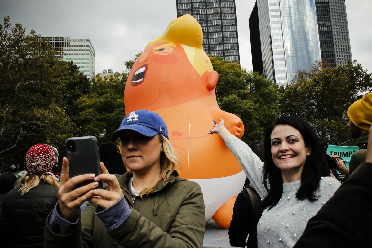 October 28: People take selfies as The Baby Trump Balloon rises in Battery Park as part of an “Impeachment Parade” protest in New York City. The 20-foot balloon that flew over London, Chicago and Los Angeles earlier this year made its New York debut durin