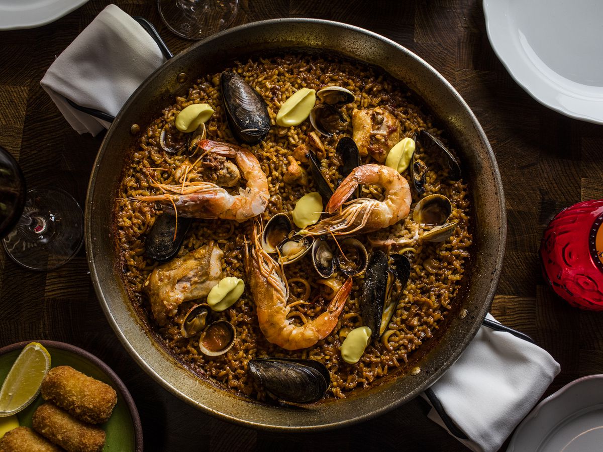 An overhead shot of a round dish of paella filled with rice and seafood.