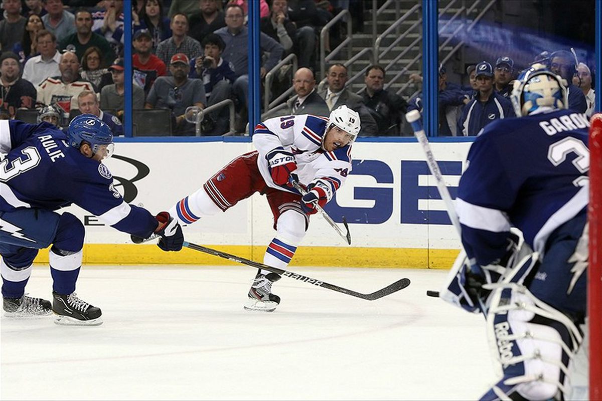 New York's Brad Richards takes aim at Lightning goaltender Mathieu Garon while being defended by Keith Aulie.