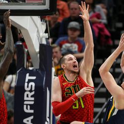 Atlanta Hawks center Dewayne Dedmon (14) and forward Mike Muscala (31) go up to defend against a shot from Utah Jazz forward Jonas Jerebko (8) during the game at Vivint Smart Home Arena in Salt Lake City on Tuesday, March 20, 2018.