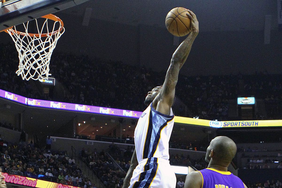 Tony Wroten dunks while Kobe Bryant stands there.