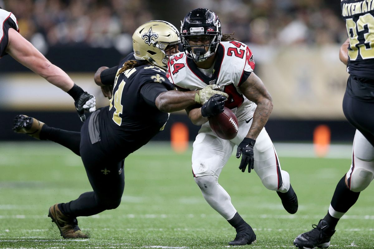 Atlanta Falcons running back Devonta Freeman nearly fumbles the ball against New Orleans Saints defensive end Cameron Jordan in the first quarter at the Mercedes-Benz Superdome.