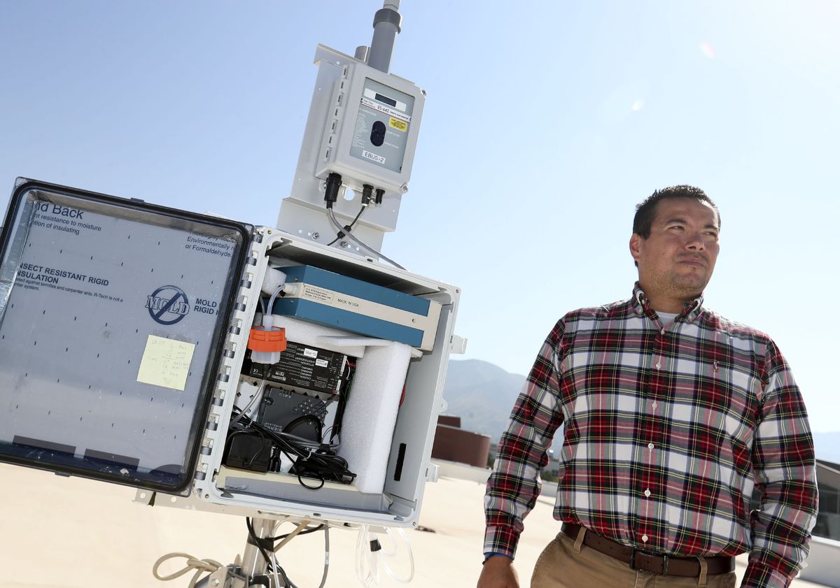 Daniel Mendoza, a professor in atmospheric science, pulmonary medicine and metropolitan planning, is photographed with an air quality monitoring station on the roof of the Spence and Cleone Eccles Football Center at the University of Utah in Salt Lake City on Friday, Sept. 23, 2021.