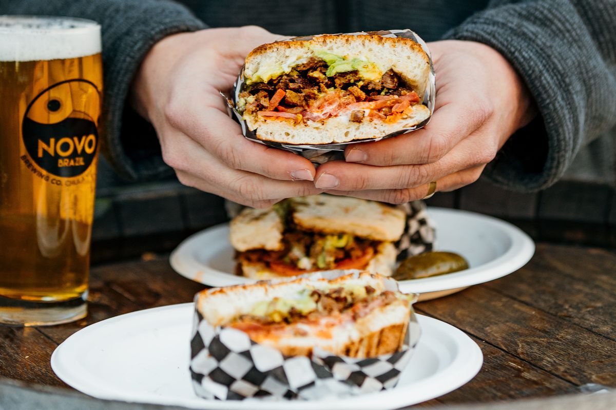 Hands hold a Mexican torta sandwich.