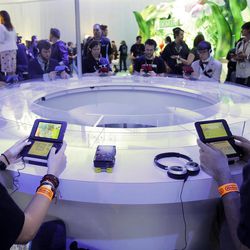 Attendees play video games on the Nintendo 3DS at the Nintendo Wii U software showcase  during the E3 game show in Los Angeles, Tuesday, June 11, 2013. 