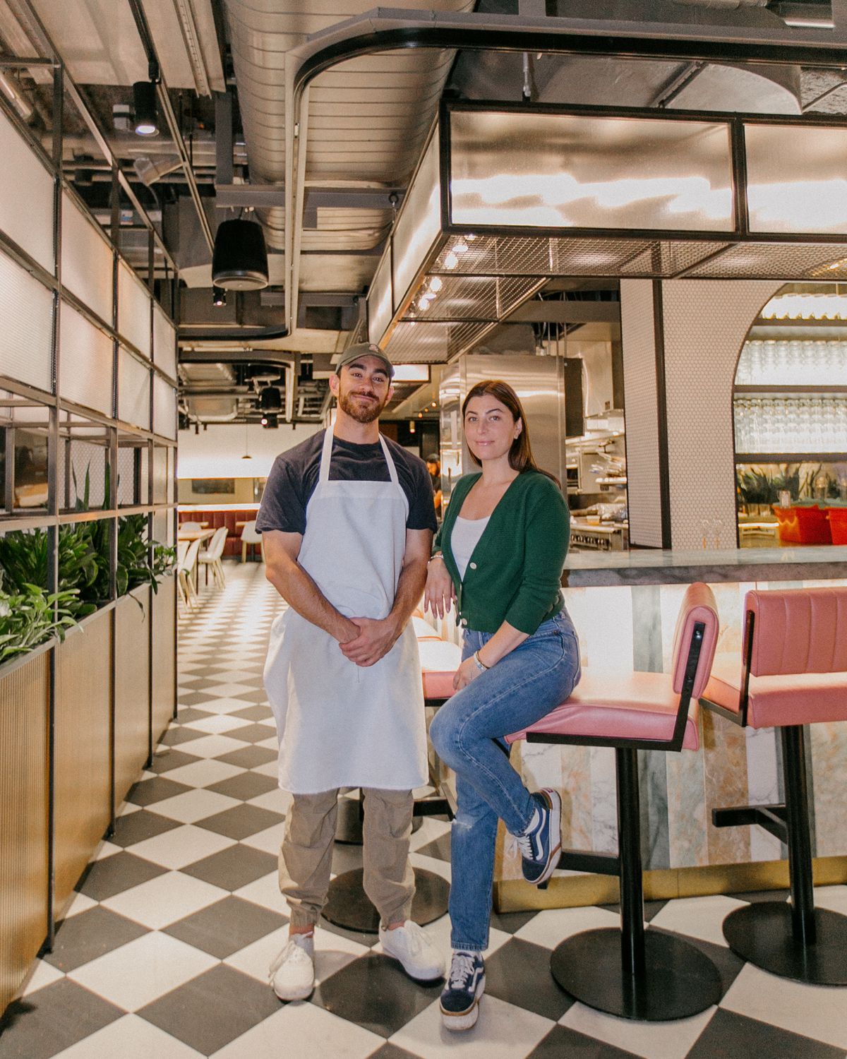 man and woman standing inside restaurant with clack and white checkered floors