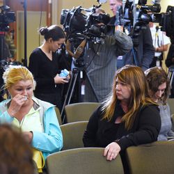 Long time Crystal Lake resident Danielle Hein, left, wipes away tears after sitting in a press conference Wednesday at the Crystal Lake village hall where officials announced charges against the parents of Andrew “AJ” Freund for his death. | Paul Valade/Daily Herald
