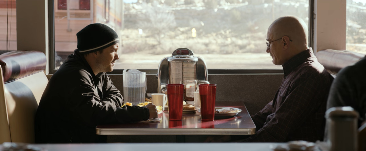 Jesse (Paul) and Walter (Cranston) sit across from each other in a restaurant booth.
