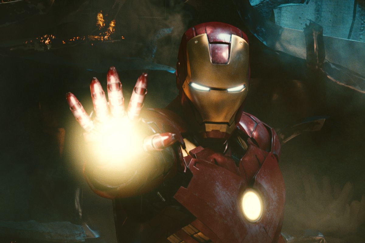 A still from Iron Man 2 in which Tony Stark is holding up his right hand charging a repulsor ray