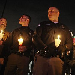From left, Tom Caygle his son, also Tom Caygle, Justin Richins and his wife, Megan, take part in a candlelight vigil honoring Ogden police officer Jared Francom and the other wounded officers at the Ogden Amphitheater in Ogden Thursday, January 5, 2012.  Jared Francom succumbed to his injuries after he and five other officers from the Weber Morgan Narcotics Strike Force were shot last night while serving a warrant at a home in Ogden.