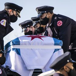 Chicago Fire Department firefighter MaShawn Plummer’s casket is loaded onto a fire truck in preparation for the procession to the cemetery after his funeral at the House of Hope church on the Far South Side, Thursday, Jan. 6, 2022.