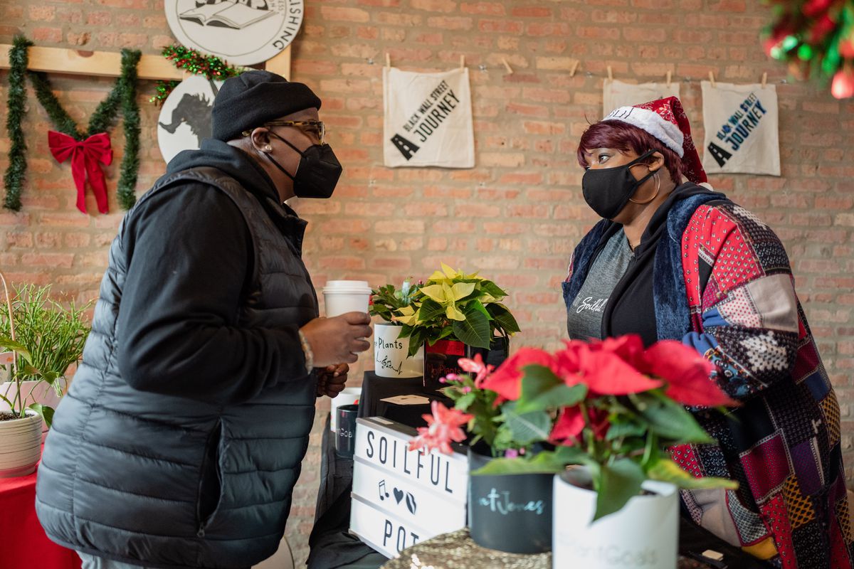 Sharnele Amos, owner of Soilful Pots, talks to a customer during a holiday pop-up market in Bronzeville on Small Business Saturday.