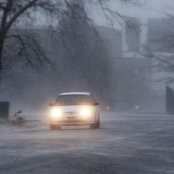 A car travels through blowing snow in Farmington, Tuesday, April 9, 2013.