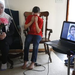 Ten-year-old Syrian Amjud Moustafa Rifat uses his shirt to wipe away tears on Tuesday, Feb. 20, 2018, in Columbus, Ohio, as he and his 18-year-old sister, Fatima, listen to a song their brother, Hasib, wrote for the family. Hasib, 16, is still in the Middle East and has been separated from his family for more than 18 months as he awaits a U.S. visa. Their father, Rifat Moustafa, an international lawyer who says he was tortured for protesting human rights violations, was granted asylum and his wife and four other children followed in 2016, before President Trump was elected. They were hoping Hasib could come shortly after, but resettlement officials say the Trump administration’s travel ban on refugees from mostly Muslim countries has very likely caused further delays.