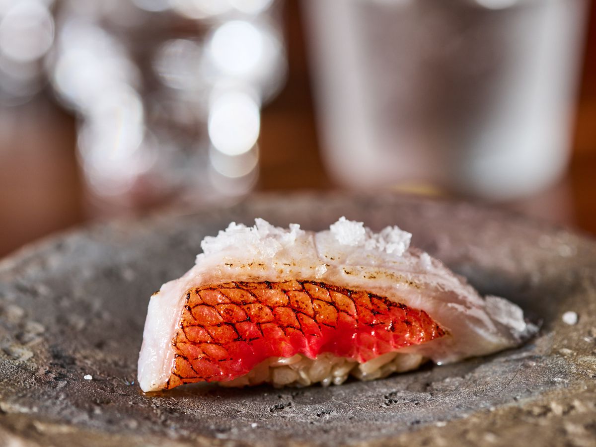A piece of orange-skinned fish sprinkled with salt.
