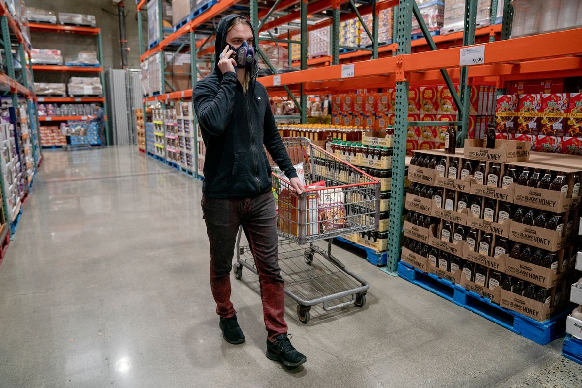 A man wearing a breathing mask shops for nonperishable groceries at Costco in Washington state.