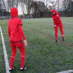 Afghani national soccer team player Shabnam Mabarz, seen from behind, watches as Khalida Popal, the former Afghanistan national women's team captain, heads the ball in Copenhagen on Tuesday, March 8, 2016. The new Afghanistan national women's soccer team uniform was revealed on Tuesday, featuring an integrated hijab. 