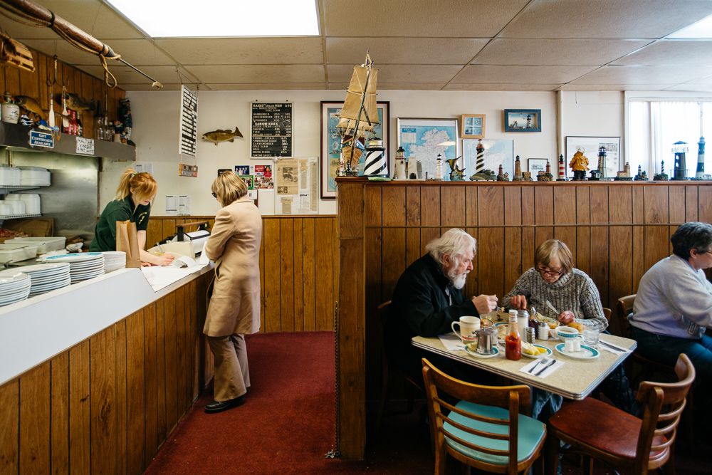 Customers sit at tables and order from the counter in the wood-paneled dining room at Scotty Simpson’s. 