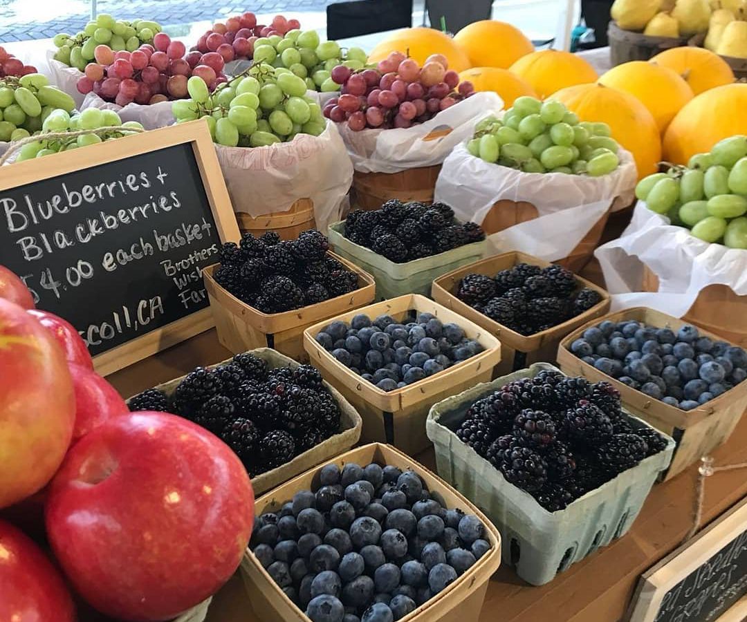 Blueberries, blackberries, grapes, and oranges sit for sale at a stand at the Frisco Fresh Market, in Texas.