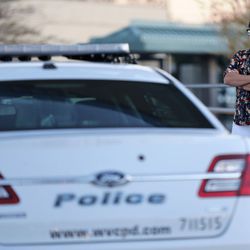 Yohana Gardner visits the patrol car of West Valley police officer Cody Brotherson outside the police station in West Valley City on Monday, Nov. 7, 2016. Gardner's husband is a police officer. Brotherson was killed in the line of duty Sunday.