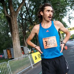 Jerrell Mock, 23, of Providence, catches his breath after finishing first in the Deseret News 10K at Liberty Park in Salt Lake City on Tuesday, July 24, 2018.