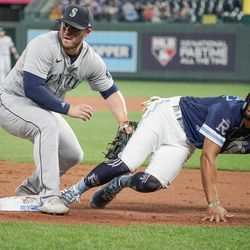 Sep 23, 2022; Kansas City, Missouri, USA; Seattle Mariners third baseman Ty France (left) tries to tag Kansas City Royals catcher MJ Melendez (1) at third base but did not have the ball in glove in the third inning at Kauffman Stadium. Mandatory Credit: Denny Medley