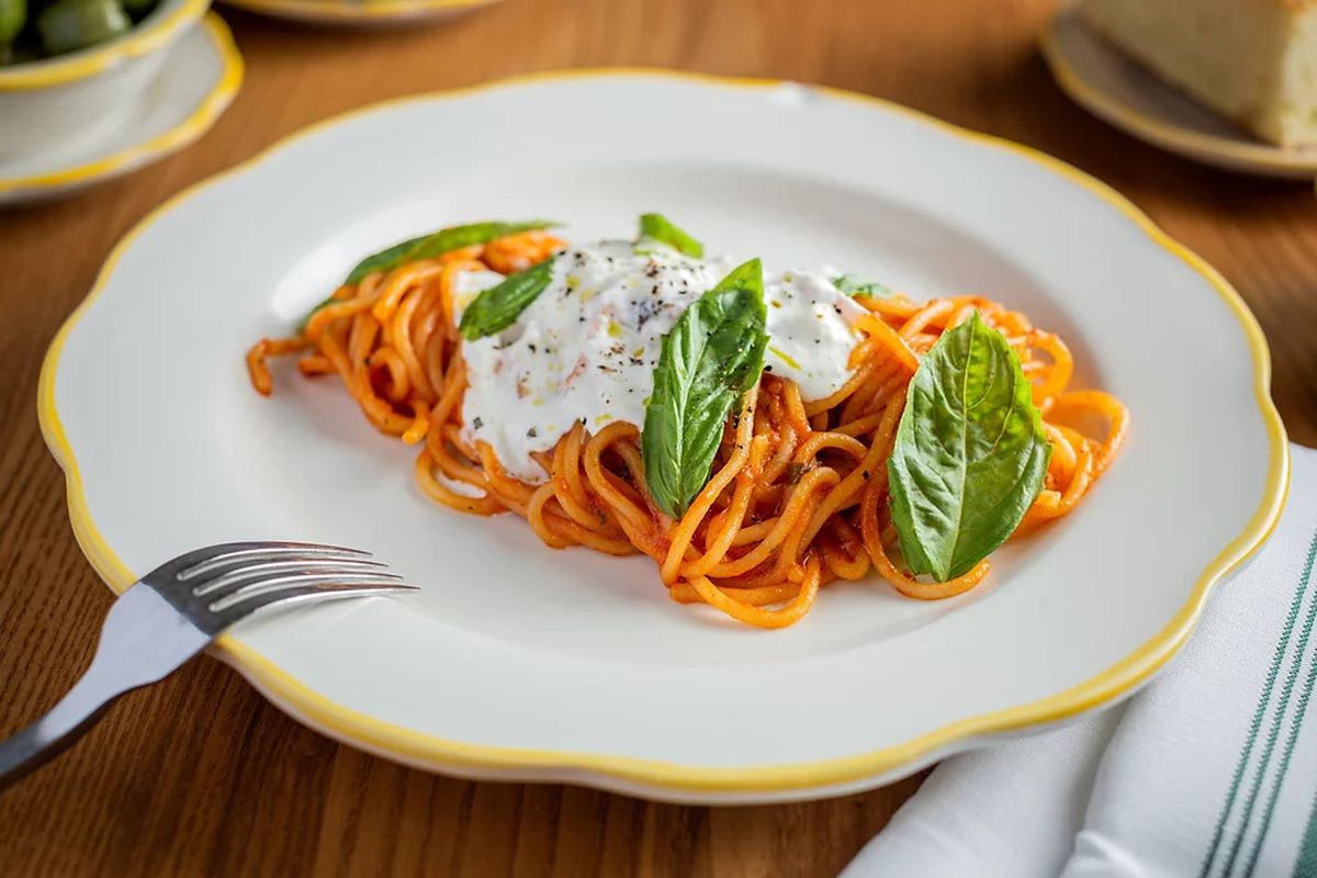 A plate of spaghetti pomodoro topped with stracciatella.