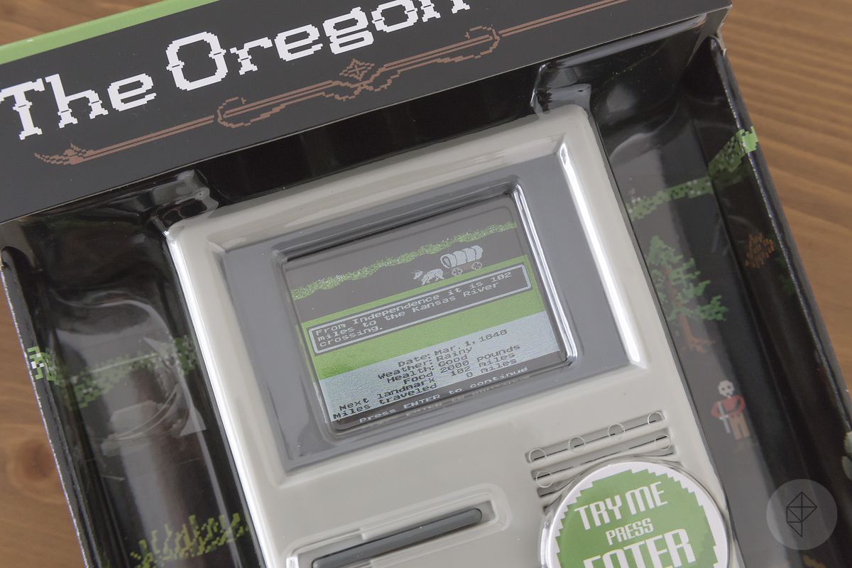 A close-up of the packaged product, The Oregon Trail handheld game, with the demo running.