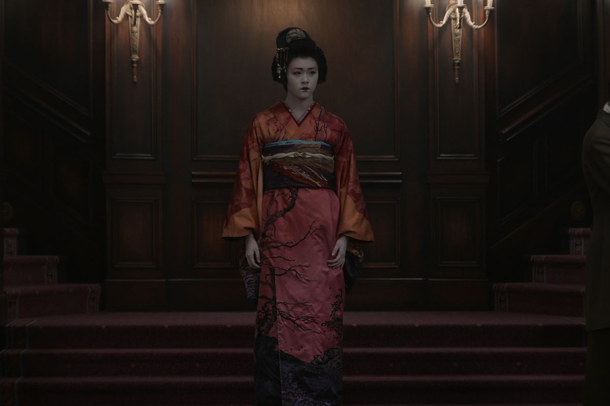 Actor Isabella Wei as Ling Yi descends a set of stairs while wearing ornate white makeup and a hanfu in a still from Netflix’s 1899
