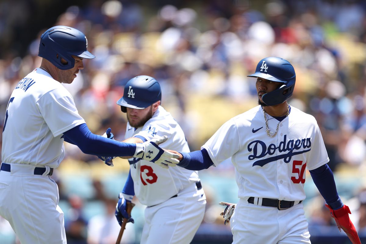 Mookie Betts #50 of the Los Angeles Dodgers celebrates his run with Freddie Freeman #5, and Max Muncy #13, to take a 1- 0 lead over the Minnesota Twins, during the third inning at Dodger Stadium on May 17, 2023 in Los Angeles, California.