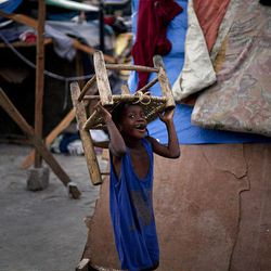 A child carries a chair in a street in Port-au-Prince, Thursday, Feb. 11, 2010. 