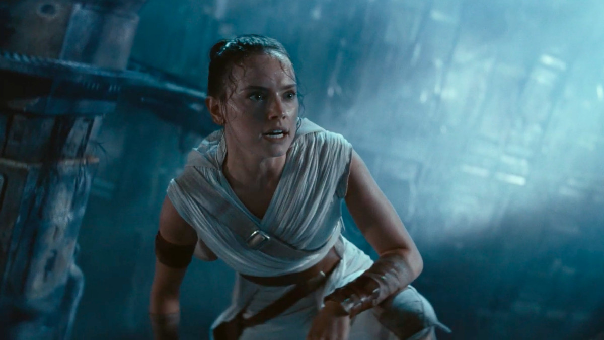 rey climbs up a piece of the fallen death star and takes a deep breath